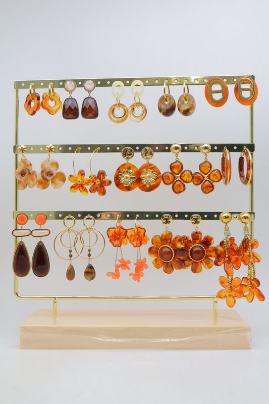 Lot de 15 paires de boucles d'oreilles marron assorties, en acier inoxydable, montées sur un présentoir métallique avec un socle en bois.