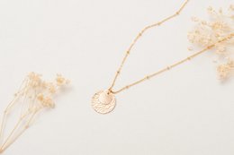 Gold circular pendant necklace with delicate chain