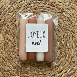 Cozy, festive candles in warm, holiday colors. Includes tall, round candles in shades of pink and white.