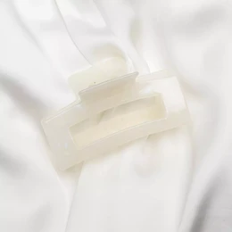 Beige classic claw hair clip, made of plastic material, suitable for casual or formal hairstyles.