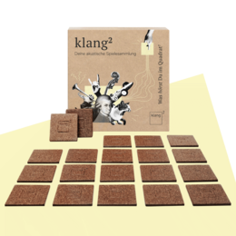The klang² game collection - bookbinder edition is a board game with a wooden game board and pieces. The game features a minimalist, abstract design with geometric shapes and patterns in neutral colors like brown and black.