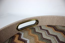 Rond bruin dienblad met zigzagpatroon met messing handgrepen