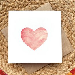 A pink heart-shaped card with a watercolor-style design, suitable for birthday celebrations.