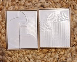 Decorative paintings for a dollhouse, featuring abstract geometric designs in white on a neutral background.