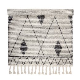 A nature-inspired cotton rug with a geometric pattern of triangles and diamonds in shades of gray.