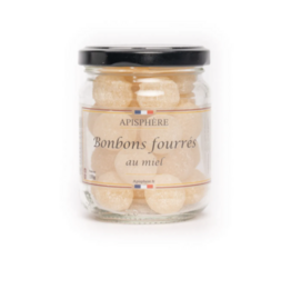 Honey-flavored candy in a glass jar. Sweet, golden-colored confections.