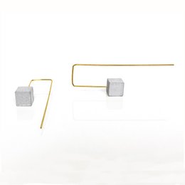 Creoles concrete // METRIC Light - Hoop earrings with a minimalist, geometric design featuring a concrete cube suspended from a gold-tone wire.