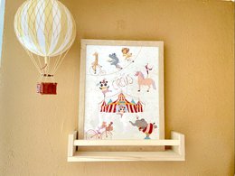 A colorful circus-themed poster featuring various animals and circus elements. The poster includes a hot air balloon, a circus tent, animals like a giraffe, elephant, and horse, as well as circus performers and props.