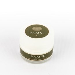 A white and green jar containing a day cream with argan oil. The product is suitable for facial skin care.