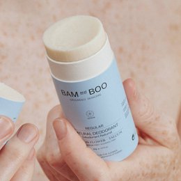  Natural deodorant in various scents including cotton flower, sandalwood, aloe vera, tea rose, lemon, and sea salt. Cylindrical packaging in green and pink colors.