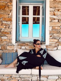 Long black kaftan with loose, flowing silhouette. Made of lightweight, breathable material. Ideal for beach cover-up or casual summer wear.