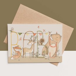 Illustrated card with a bear and baby in a laundry basket, with colorful garlands above. The card appears to be for a baby or new parent.