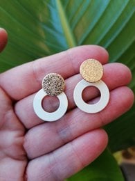Elegant statement earrings featuring a gold-toned textured disc and a white circular frame. Suitable for formal or casual wear.