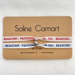 Colorful woven bracelet with text "Beaucoup, Passionately, Un Peu, Beaucoup" in a stylish design.