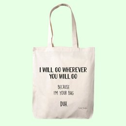 A white tote bag with the text "I will go wherever you will go because you're my dude" printed on it. The bag has a simple, minimalist design with a brown strap.