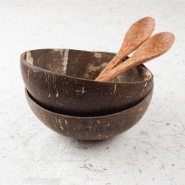 Two natural coconut bowls with wooden spoons, perfect for serving food or drinks.
