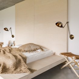  Rectangular wall light with two adjustable spotlights in a modern, minimalist bedroom setting.