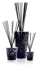 Reed diffuser set with dark purple glass containers and black reed sticks. The set includes a large and small container.