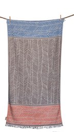 A large, rectangular beach towel with a geometric pattern in shades of blue, coral, and white. The towel has a striped border and appears to be made of a soft, absorbent material.