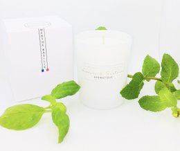 A tall, round white candle with a cotton wick, infused with the fresh scent of mint and basil.