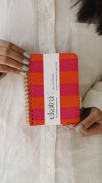 Red and white striped spiral-bound journal, compact A6 size, colorful geometric pattern design.