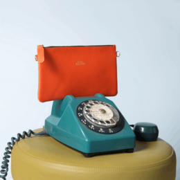 A stylish two-tone clutch with a glittery exterior and a detachable strap for versatile wear. Available in a range of color combinations including beige/gold, camel/gold, and more.
