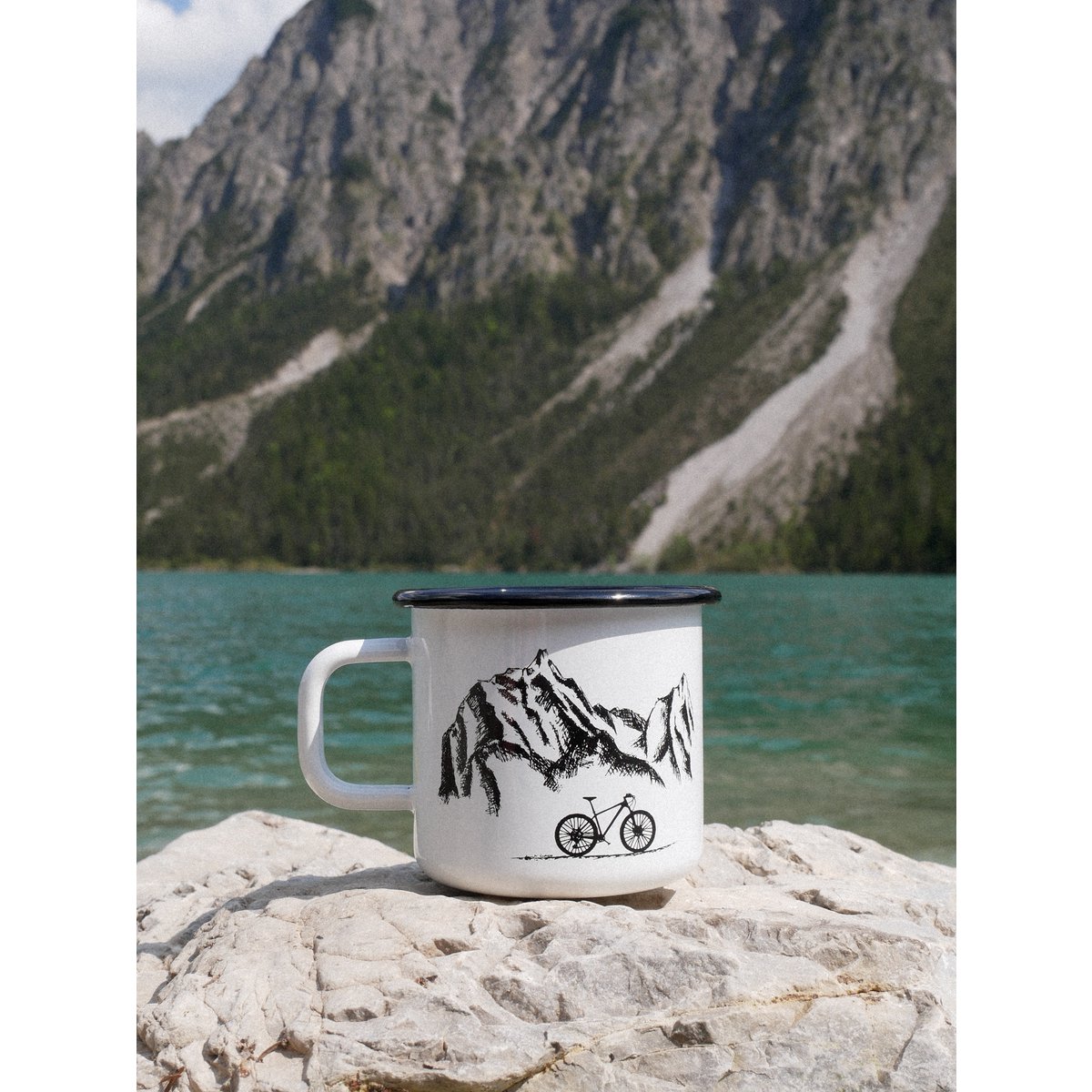 Taza esmaltada montañas y rueda.