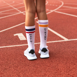 White tube socks with red, white, and blue stripes and text "MAKIN' HISTORY" printed on them.