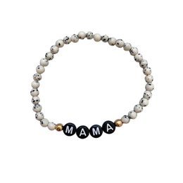 A beaded bracelet with the word "MAMA" spelled out in black beads, surrounded by gray and white beads. This bracelet appears to be a maternity or motherhood-themed accessory.