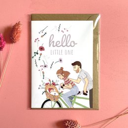 A folding card with a cute illustration of a family, featuring the text "Hello little one". The card appears to be a baby card or greeting card.