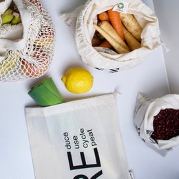 Organic cotton lunch bags in various sizes, including Lille madpose (20 cm x 25 cm), Mellem madpose (25 cm x 30 cm), and Stor madpose (30 cm x 38 cm). The bags feature text designs like "think globally - act locally" and "one step forward". The bags are made of natural, sustainable materials and are suitable for carrying produce or other food items.