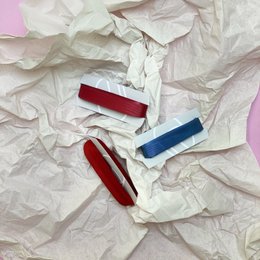 Colorful ribbon set for wrapping gifts and decorating. Includes red, blue, and white ribbons in various shapes and textures.
