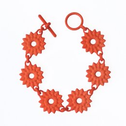 Flower chain bracelet with orange dahlia-shaped charms. Made of a linked chain of bright tangerine-colored flower charms.