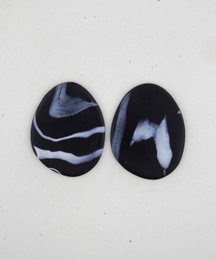 Small drop earrings with a swirling black and white pattern design.