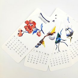 A mini wall calendar featuring nature-inspired illustrations for the year 2024. The calendar showcases a variety of colorful floral and botanical designs, including flowers, leaves, and other natural elements.
