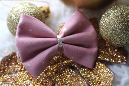 A pink and gold hair clip with polka dot accents, part of a collection of kids' hair accessories.
