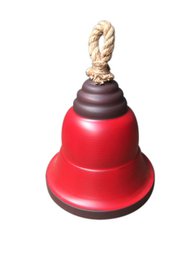 A red, green, and white Christmas bell decoration with a rope handle and a dark base.