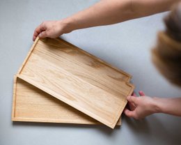 Rectangular wooden serving tray with two compartments, one holding sliced lemon and the other containing dried fruit.