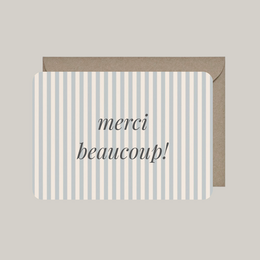 Elegant thank you card with French text "merci beaucoup!" and striped pattern envelope.