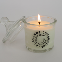 A round, tall glass candle with a white label that reads "Lavande de l'Esterel" (Lavender from the Esterel). The candle has a warm, flickering flame and appears to be a scented candle.