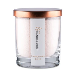 Pomegranate Spice scented candle in a glass container with a copper-colored lid. The candle has a pink wax and is burning, creating a warm and inviting atmosphere.