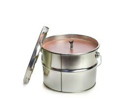 Two stacked tin candle holders in a brick color, each measuring 18 x 14 cm. The candle holders have a metal lid and contain a scented candle.