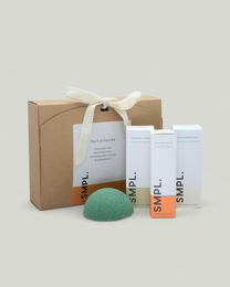 Skincare gift set with white bottles, green soap, kraft paper packaging, spa beauty kit with ribbon bow.