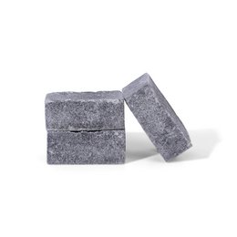 Amber-colored block candle with a musk scent. Rectangular shape with a textured, stone-like surface.