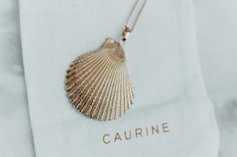 Gold-toned seashell pendant necklace with delicate chain.