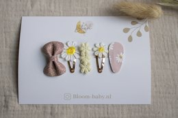 A set of colorful hair clips for kids, featuring a variety of shapes and designs including bows, flowers, and leaves.