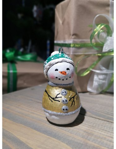 Handgemaakte sneeuwpop van papier-maché met een groene hoed