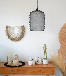 Black stainless steel wire mesh lampshade with a unique, geometric design. Made of durable materials and suitable for use in modern or industrial-style home decor.
