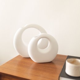 White ceramic vases with abstract, organic shapes. Available in big and small sizes.