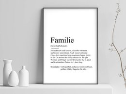 A black and white poster with the word "Familie" and a definition-style description of the word. The poster has a minimalist, typographic design and is displayed in a simple frame against a neutral background.